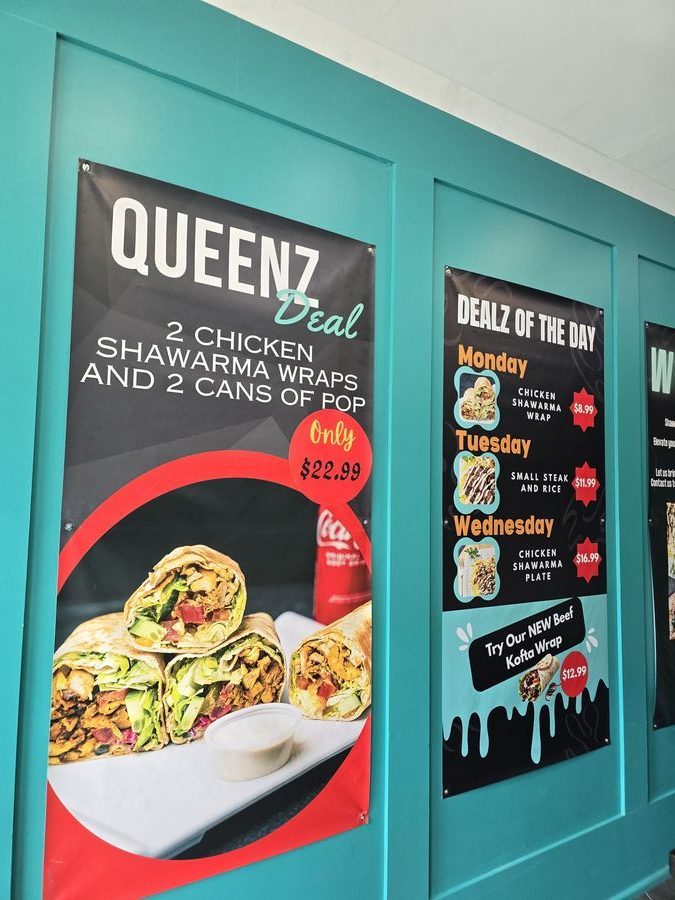 Inside Shawarma Queenz — teal walls and dealz posters